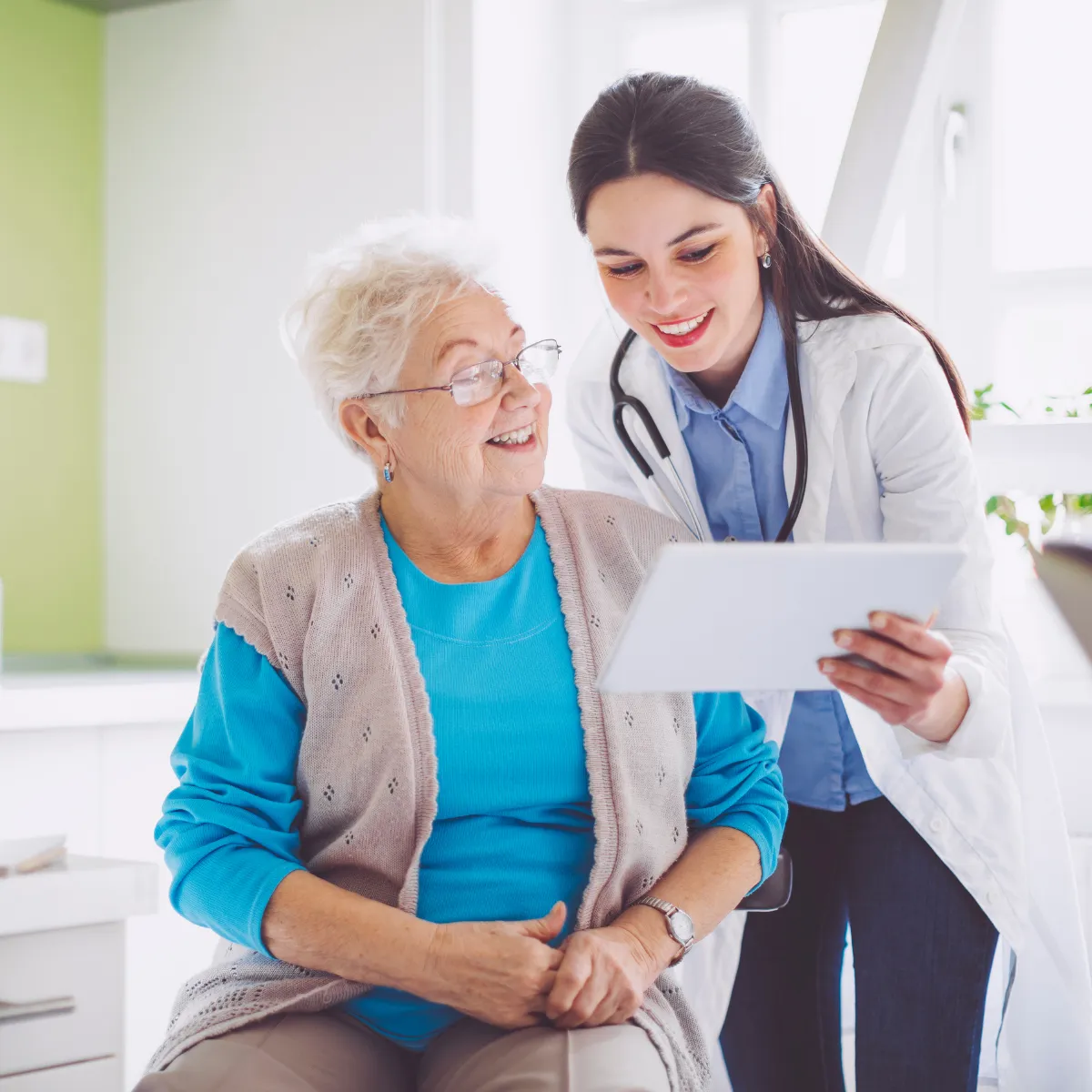 Doctor and older woman looking at tablet