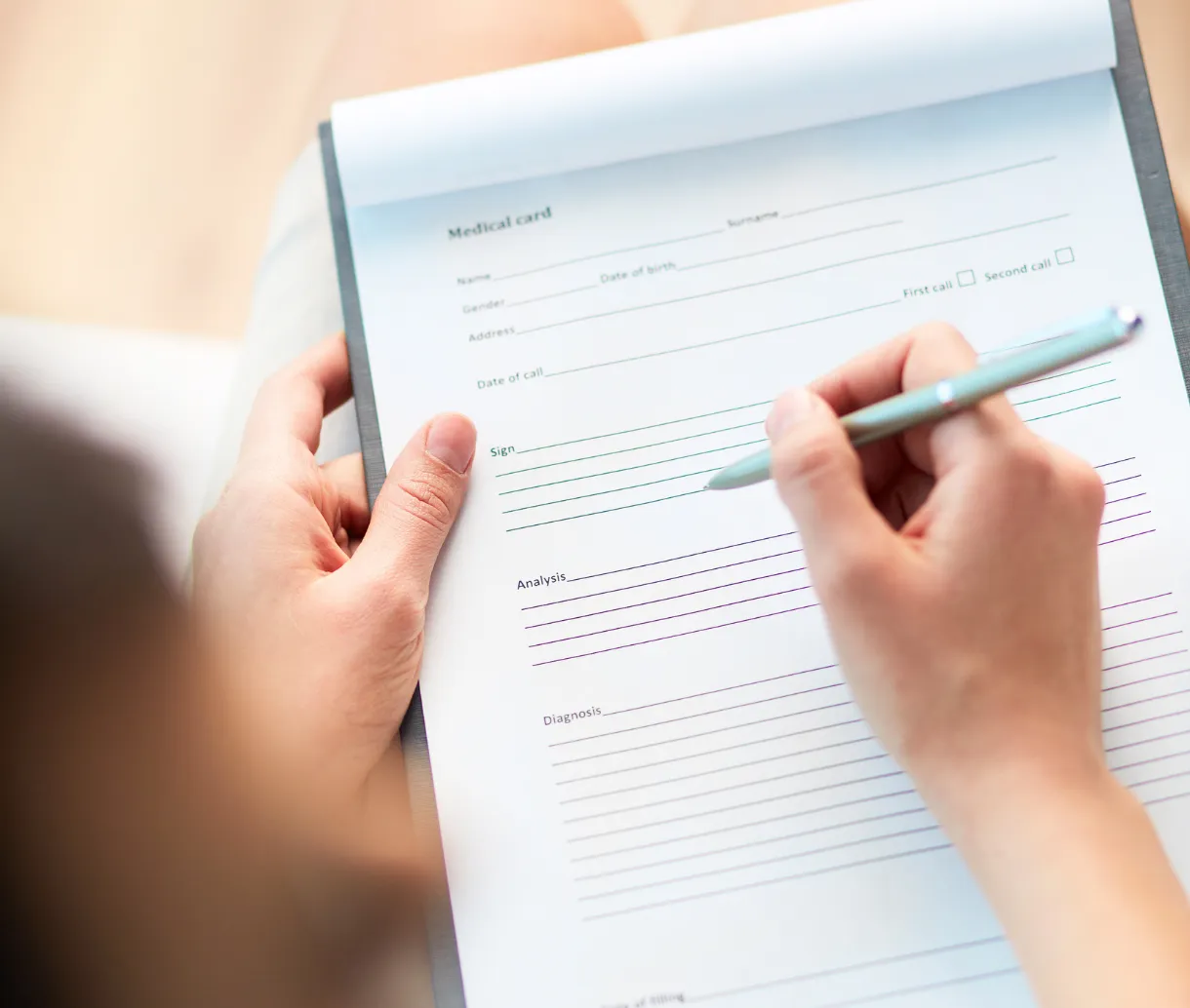 Person writing on a medical card