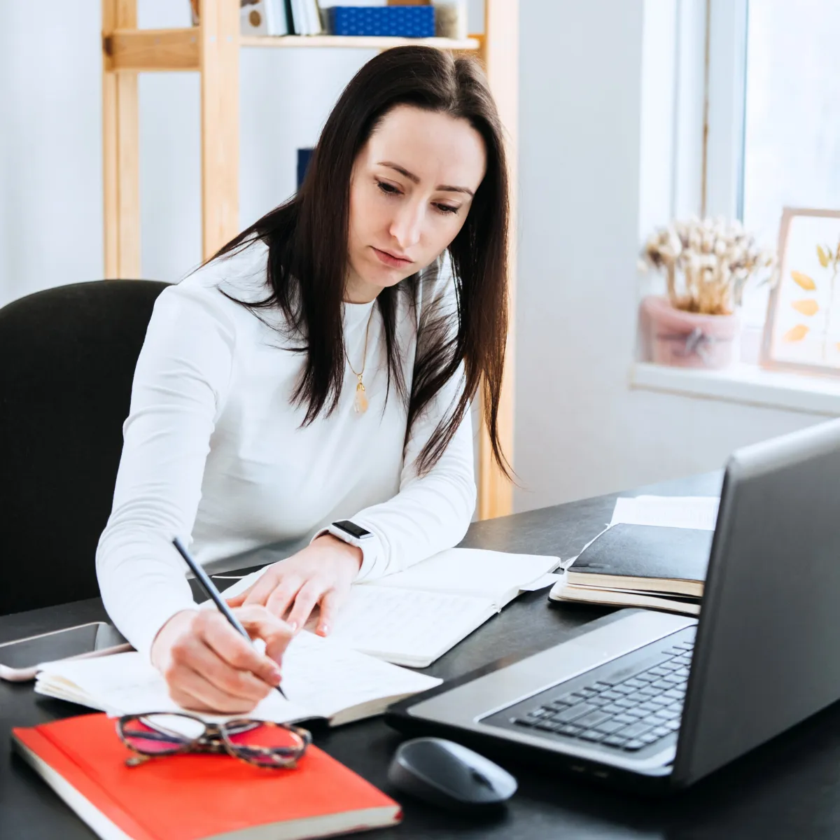 woman at desk writing on papers