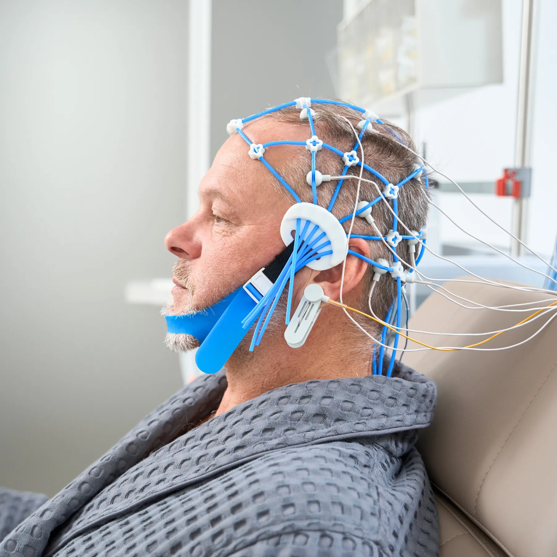 Man with apparatus on head that has many wires connected