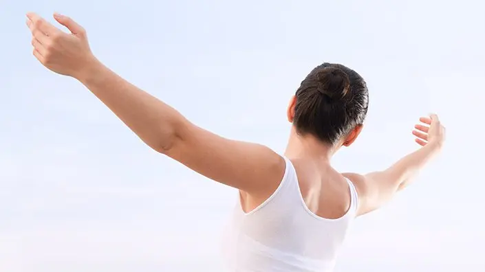 woman with arms spread outdoors