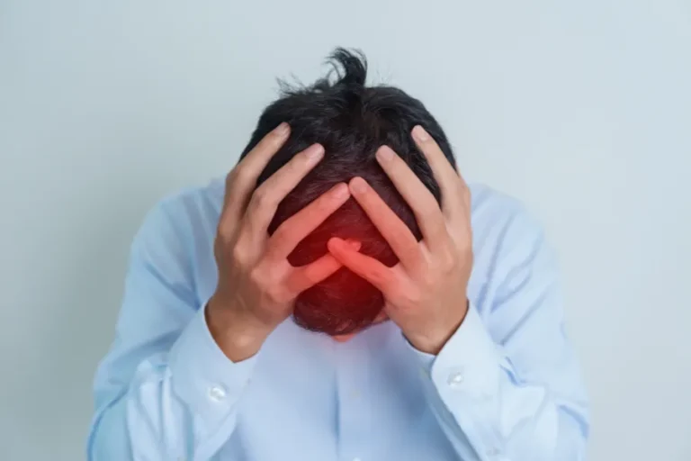 Man holding head in pain showing migraine symptoms and severe headache